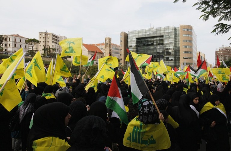 Lebanon''s Hezbollah supporters wave flags during a demonstration against Israel''s military operation in Gaza, in front of the U.N. headquarters in Beirut