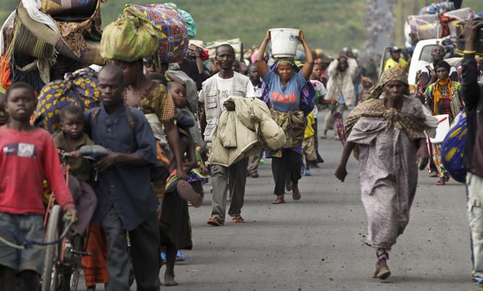 Residents of Sake walk toward Goma