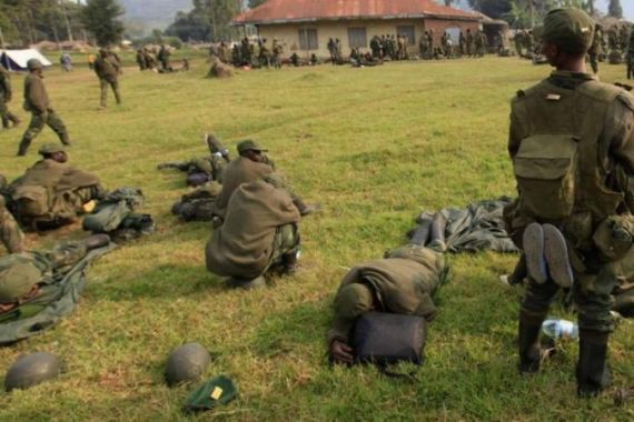 Soldiers from Democratic Republic of Congo rest in a field in Uganda border town of Kisoro