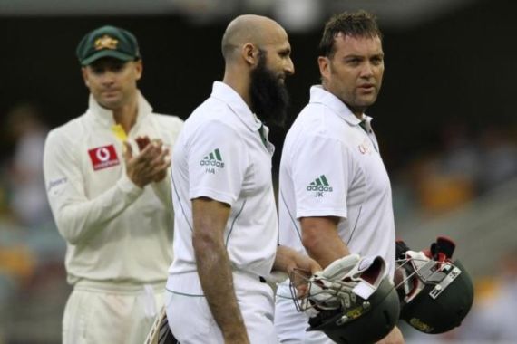 South Africa''s Kallis and Amla leave the ground as Australia''s Clarke looks on, after the end of the first day of the first cricket test match at the Gabba in Brisbane