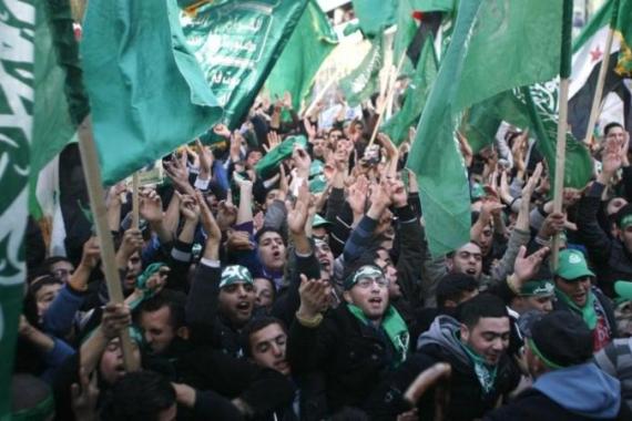 Palestinians wave Hamas flags during a rally in Nablus