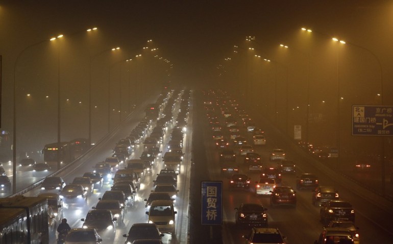 Vehicles drive on the Third Ring Road on a very hazy winter day in Beijing