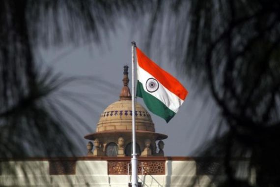 An Indian national flag flutters on top of the Indian parliament building in New Delhi
