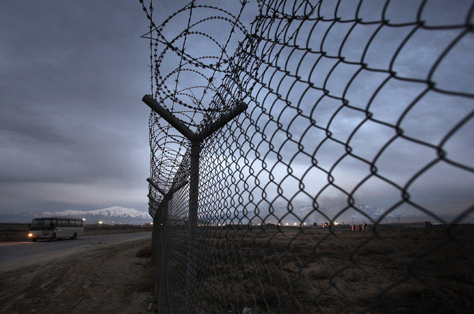 A bus passes a security fence at Bagram Air Base March 2, 2009 in Bagram, Afghanistan [Spencer Platt/Getty Images]