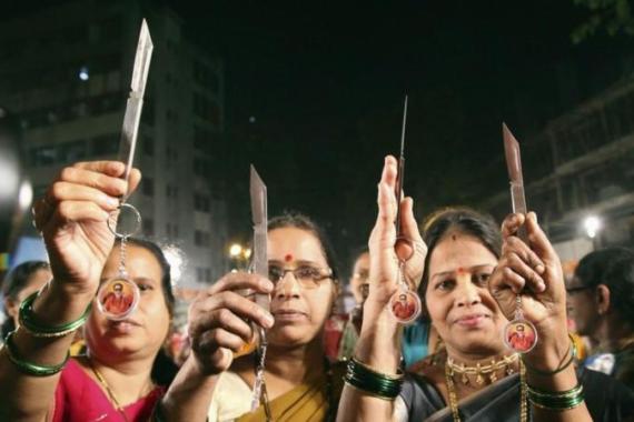 Women pose with knives, distributed by India''s radical Hindu nationalist party Shiv Sena, in Mumbai