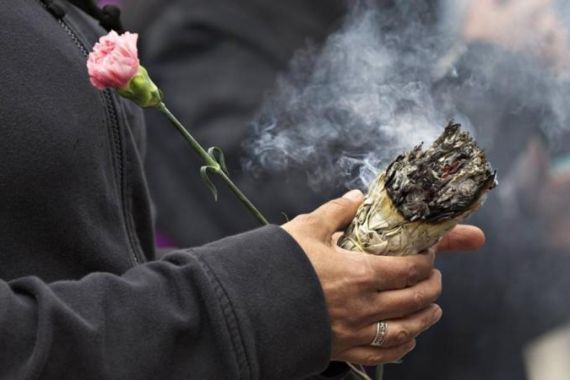 A native woman burns sweet grass during a protest outside the Missing Women''s Inquiry in Vancouver