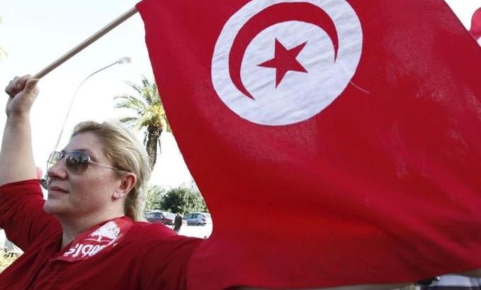 A woman waves a Tunisia flag during a rally to protest against religious and political violence in Tunisia, on Avenue Habib Bourguiba in Tunis
