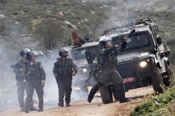 An Israeli border policeman fires tear gas at Palestinian stone throwers in the West Bank village of Kusra, near Nablus