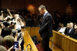 Oscar Pistorius stands at the dock before the start of proceedings at a Pretoria magistrates court February 22, 2013 [Mike Hutchings/Reuters]