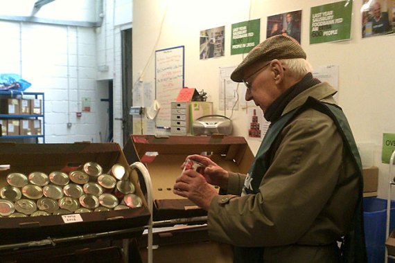Volunteer Derek Fishleigh sorts food at the Trussell Trust’s Salisbury warehouse. [Gavin O’Toole/Al Jazeera]