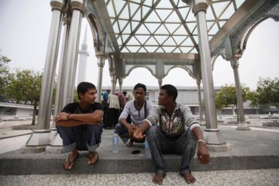 Ethnic Rohingyas from Myanmar and living in Malaysia talk as they wait for a prayer outside a mosque in Kuala Lumpur