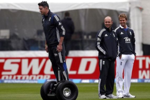 England cricket team player Pietersen rides a Segway past teammates Trott and Compton during a rain delay on the first day of the first test against New Zealand at the University Oval in Dunedin
