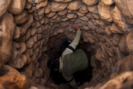 Amir Heidary climbs down the stone shaft of an ancient waterway in Iraq