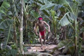 A Yanomami Indian runs in the jungle at the community of Irotatheri