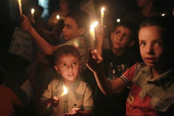 Palestinian children hold burning candles during a protest in the northern Gaza Strip
