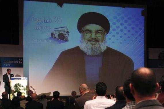 People applaud as Lebanon''s Hezbollah leader Nasrallah appears on a screen during a live broadcast at an event marking the 25th anniversary of the establishment of Al-Nour radio station in Beirut