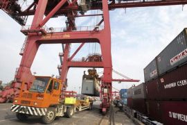 A truck is loaded with a shipping container at a port in Nantong