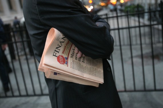 A businessman, with a copy of the Financial Times newspaper under his arm, waits to enter the New York Stock Exchange Friday, Oct. 10, 2008 in New York. (AP Photo/Mark Lennihan)