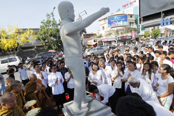 Cambodian workers pray next to a statue of former President of the Free Trade Union of the Workers