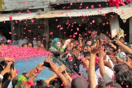 Maryam Nawaz is covered in rose petals as she encourages voters in Lahore [Asad Hashim/Al Jazeera]