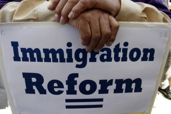 A man holds a protest sign during a rally for immigration reform in Los Angeles, California