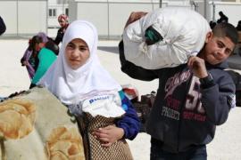 Syrian refugees with their belongings at the new Mrajeeb Al Fhood refugee camp
