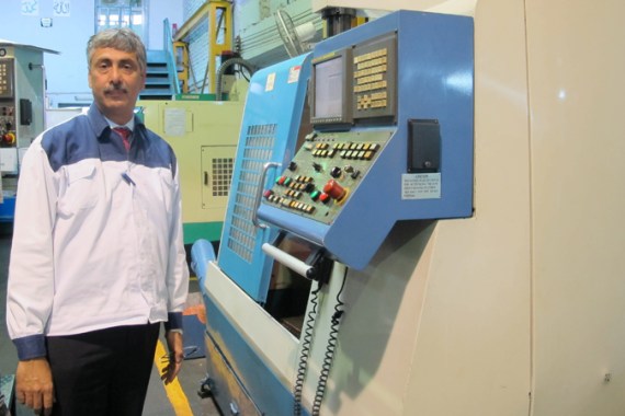 Zia Hyder Naqi, the managing director of a plastics manufacturing company, stands next to a machine that is creating a new mold