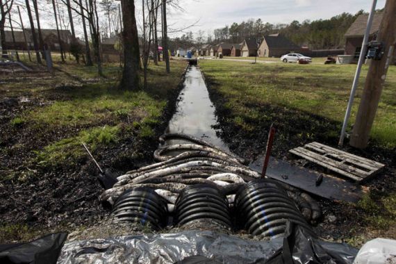 Spilled crude oil is seen in a drainage ditch near evacuated homes near Starlite Road in Mayflower, Arkansas