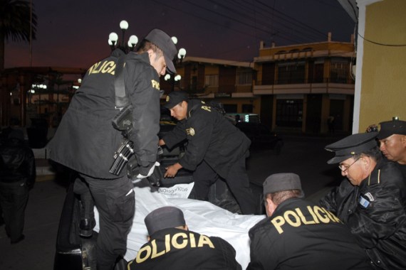 Police officers carry the corpse of one of eight colleagues