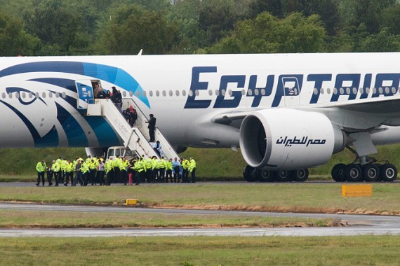 Police escort passengers off the Egyptair Boeing 777 flight from Cairo that was forced to land at Glasgow Prestwick airport