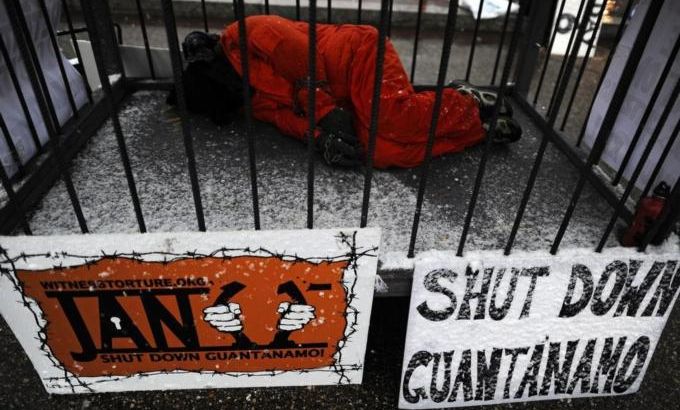 A protester, wearing orange prison suit
