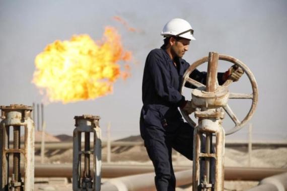 File photo of a worker adjusting the valve of an oil pipe at West Qurna oilfield in Iraq''s southern province of Basra