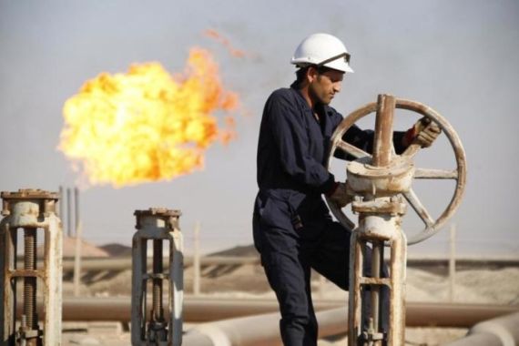 File photo of a worker adjusting the valve of an oil pipe at West Qurna oilfield in Iraq''s southern province of Basra