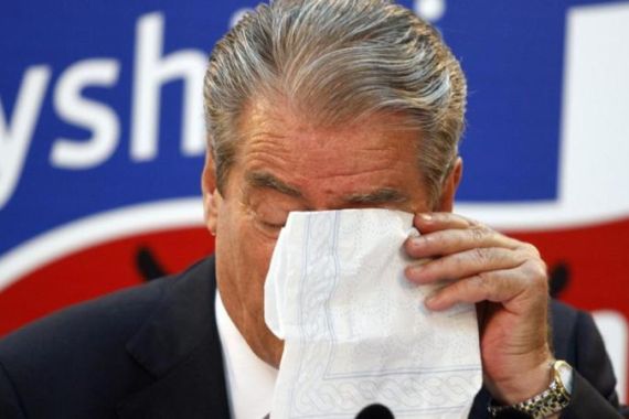 Albania''s PM Berisha wipes his tears during a news conference in Tirana