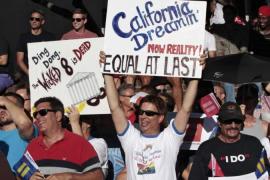 People hold signs during a community celebration for the U.S. Supreme Court ruling on California''s Proposition 8 and the federal Defense of Marriage Act, in West Hollywood