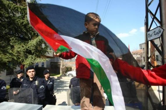 A boy waves Palestine national flag as r