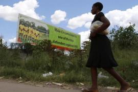 A Zimbabwean woman walks past a billboard promoting male circumcision to combat Aids in the capital