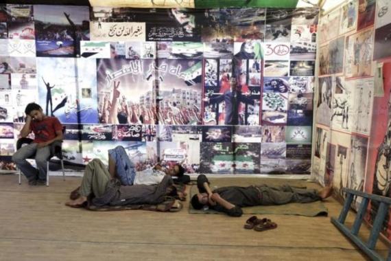 Syrians living in Egypt sleep in a tent gallery of pictures and caricatures of the Syrian uprising near Tahrir Square in Cairo