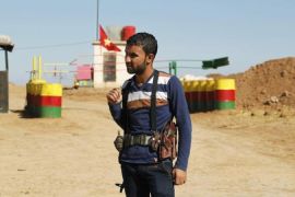 An officer of the Syrian Kurdish Democratic Union Party (PYD) stands guard near the Syrian-Iraq border