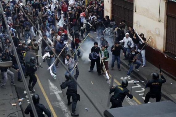 Students clash with riot police during a demonstration against the government in Lima