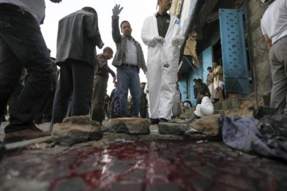 Policemen inspect the site of a roadside bomb in Sanaa