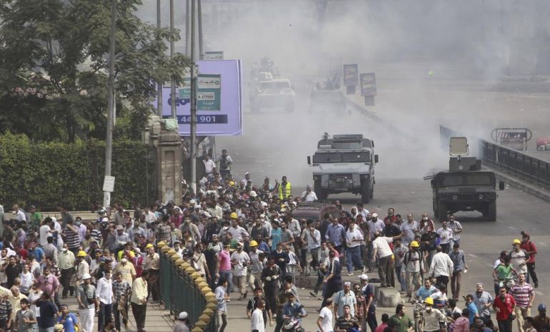 Riot police vehicles fire tear gas at members of the Muslim Brotherhood and supporters of deposed Egyptian President Mohamed Mursi, around Cairo University and Nahdet Misr Square, where they are camping in Giza