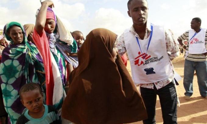 A MSF worker ushers newly arrived Somali refugees before they are administered polio vaccine at the Ifo extension refugee camp in Dadaab