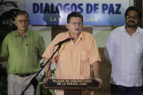 FARC negotiator Catatumbo reads a document as lead negotiator Marquez and negotiator Tellez listen in Havana