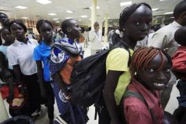South Sudanese waiting to be flown back to their country arrive at Khartoum Airport