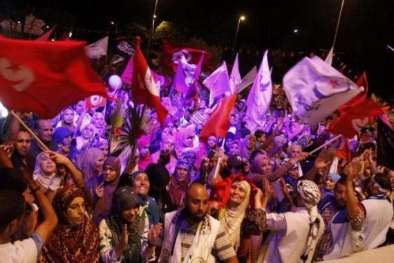 Supporters of the Islamist Ennahda movement wave flags during a demonstration outside the Constituent Assembly headquarters in Tunis