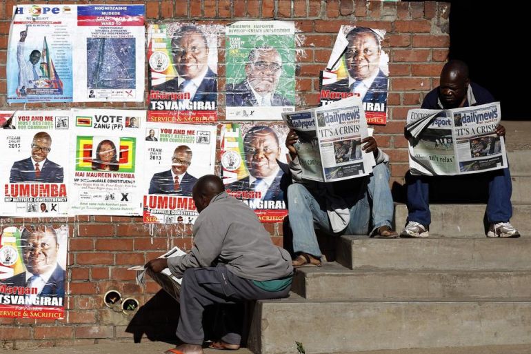 Locals read newspapers in Mbare township, outside Harare
