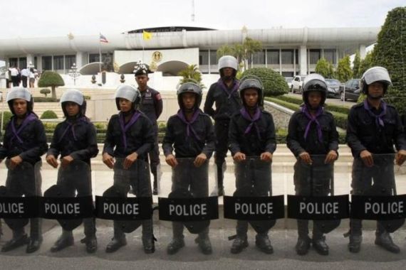 Thai riot policemen stand guard outside the parliament in Bangkok