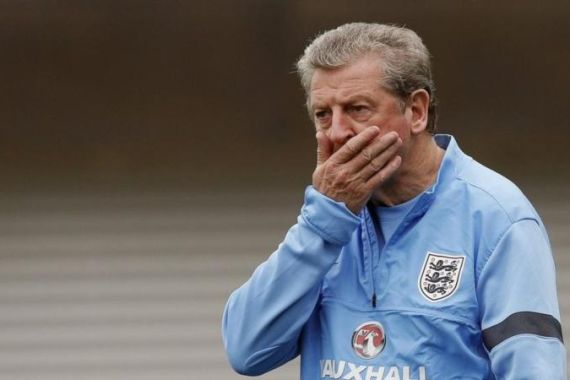 England''s coach Hodgson rubs his face as he watches his players during a training session at the St George''s Park training complex near Burton upon Trent