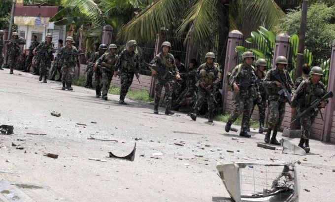 Security forces walks past debris scattered on a street after rebels from the Moro National Liberation Front (MNLF) clashed with government troops in Zamboanga city